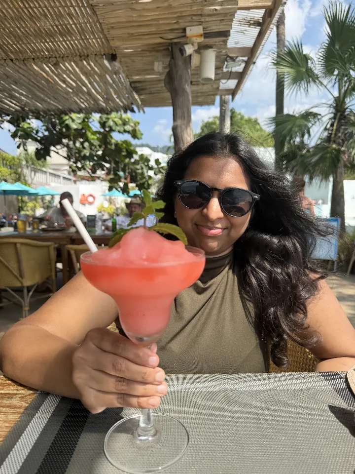 A frozen drink at a beach bar under a straw roof.
